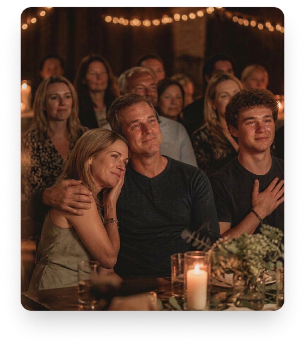 A family at a venue, watching a tribute film together