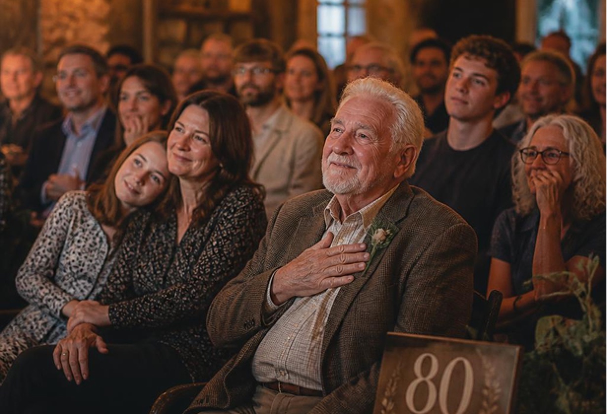 A family watching a film of their grandfather's 80th birthday
